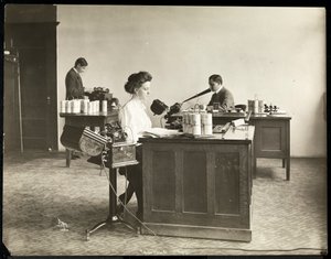 Interieur van een vrouw die typt vanaf een dicteermachine en een man die dicteert in een andere bij de Edison Phonograph Co., West Orange, New Jersey, 1903